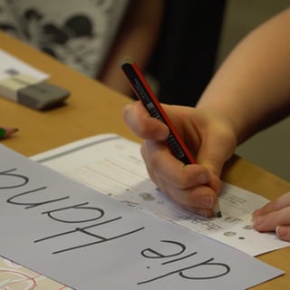 Ein Mädchen übt Buchstabenschreiben