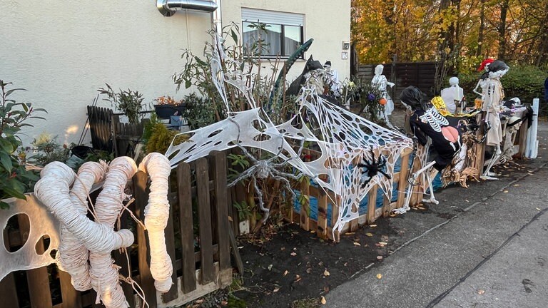 Eine riesengroße Skelett-Hand greift über den Gartenzaun, Spinnenetze und weitere schaurige Gestalten sind vor einem Haus in Reutlingen-Degerschlacht zu sehen.