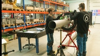 Zwei Mitarbeiter der ZAHNEN TECHNIK arbeiten in der Werkstatt.