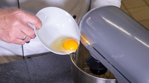 Eier für den Teig der Amerikaner werden in eine Schüssel gegeben.