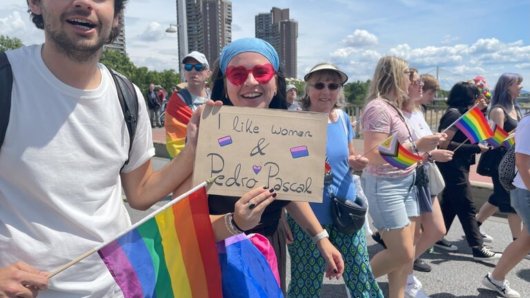 Eine Frau hält ein Plakat, auf dem steht: I like women