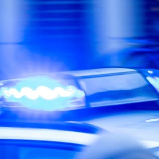 Ein Streifenwagen der Polizei ist mit Blaulicht im Einsatz. 