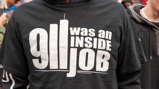 Eine Person trägt ein T-Shirt mit einer Verschwörungstheorie.