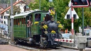 Die reich geschmückte Lok an einem der vielen Bahnübergänge.