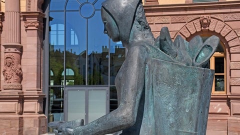 Das Denkmal einer Schuhträgerin aus schwarzem Stein vor der Alten Post