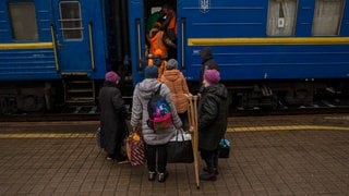 Symbolbild Zugevakuierung. Menschen stehen vor einem ukrainischen Zug.