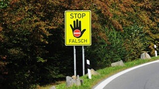 Ein Hinweisschild auf dem "Stop" steht und Falschfahrer davon abhalten soll, in die verkehrte Richtung zu fahren.