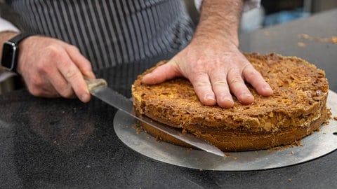 Das Messer zum Halbieren des Hefeteig-Bodens sollte einen Wellenschliff haben und so lang sein, wie der Kuchen breit ist.
