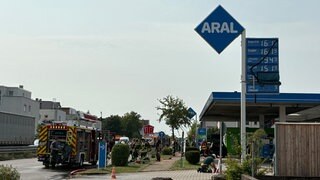 Ausgebranntes Auto an einer Neckarsulmer Tankstelle: Die Feuerwehr war mit einem Großaufgebot vor Ort, um ein Übergreifen der Flammen zu verhindern. Mehrere Gefahren drohen.
