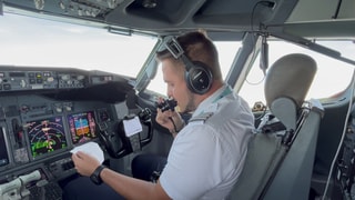 Pilot Jonas Stein sitzt im Cockpit und macht eine Durchsage. Die ist regelmäßig auch auf schwäbisch.