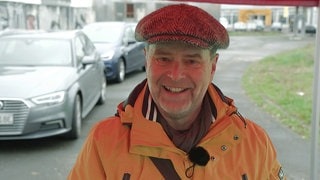 Mann in einer Mütze steht auf der Straße