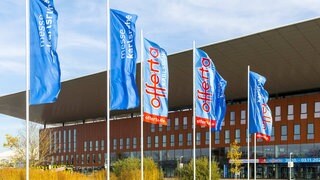 Blaue Fahnen wehen vor dem Eingang zur Verbrauchermesse offerta auf dem Gelände der Messe Karlsruhe.