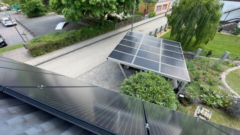 Die öffentliche E-Ladesäule ist unter einem Car-Port, dessen Dach aus Photovoltaik-Modulen besteht.