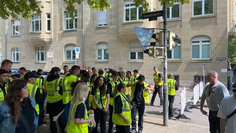 Security-Personal steht in einer Gruppe beim CSD Stuttgart 2025.