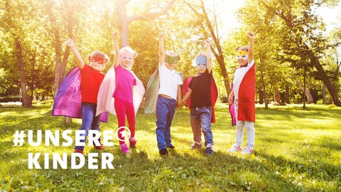 Kinder in Helden-Kostümen spielen draußen. Habt ihr auch kinderfreundliche Orte, die ihr teilen möchtet? Jetzt mitmachen bei #unsereKinder!