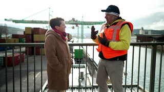 Sonja Faber-Schrecklein redet mit dem Pressesprecher des Stuttgarter Hafens, Johannes Zeller. Im Hintergrund sieht man den Neckar und Container.