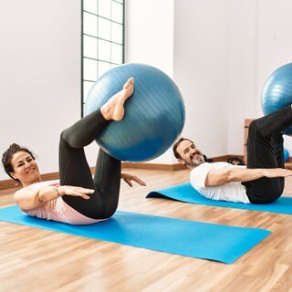 Mann und Frau machen zusammen Pilates