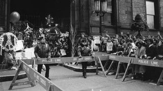 Die Polizei hält Fans am 9. Dezember 1980 vom Dakota-Gebäude in New York City zurück. Hier lebte John Lennon und am Eingang des Hauses wurde der Musiker am Tag zuvor ermordet.