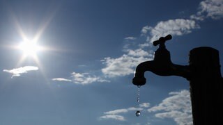 Wasserknappheit - Tropfender Wasserhahn vor blauen Himmel
