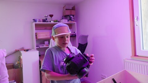 Ben Fischbach schaut sich in seinem Zimmer eine LED-Lampe an. Er plant das Benefizfestival "Lumpi Fäscht"