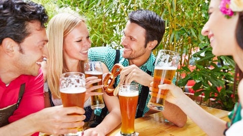 Zwei Frauen und zwei Männer im Biergarten. Eine Studie zeigt: Nach dem Trinken von Bier wirken Menschen auf Stechmücken attraktiver - Alkohol kann sie also zusätzlich anziehen.