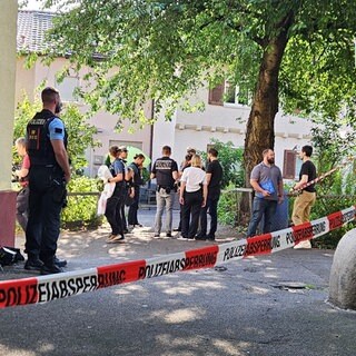 Nach dem tödlichen Schuss bei einem Polizeieinsatz stehen Einsatzkräfte in der Nähe des Tatorts in Stuttgart-Ost.