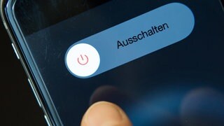 ILLUSTRATION - Eine Frau schaltet ihr Smartphone aus. Rund 100 Kinder und Jugendliche einer Integrierten Gesamtschule in Rheinland-Pfalz haben gut drei Wochen auf ihr Smartphone verzichtet.