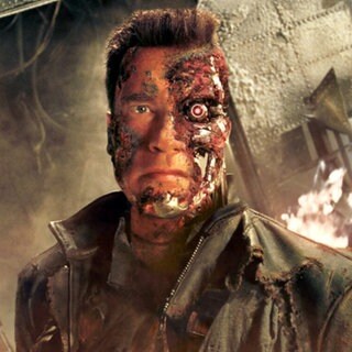 Der Terminator (Arnold Schwarzenegger) steht im Kinofilm „Terminator 3 - Rebellion der Maschinen“ vor einem brennenden Wrack (Szenenfoto). 