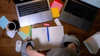 Zettelchaos auf einem Schreibtisch | Wie Prokrastination mit ADHS zusammenhängt und was dagegen hilft