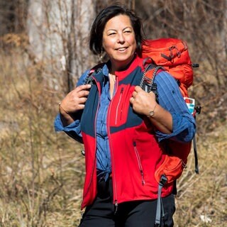Wanderin mit Wanderhose, Wanderhemd, Wanderweste und Rucksack