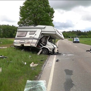 Eine Unfallstelle an der ein schwer beschädigtes Wohnmobil und ein PKW-Wrack zu sehen sind