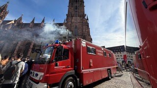 Auf dem Münsterplatz in Freiburg wird ein Feuerwehreinsatz simuliert.