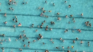 Viele Menschen schwimmen dicht an dicht in einem Freibad: Der Sommer hat viele Freibad-Fans in die Bäder gelockt.