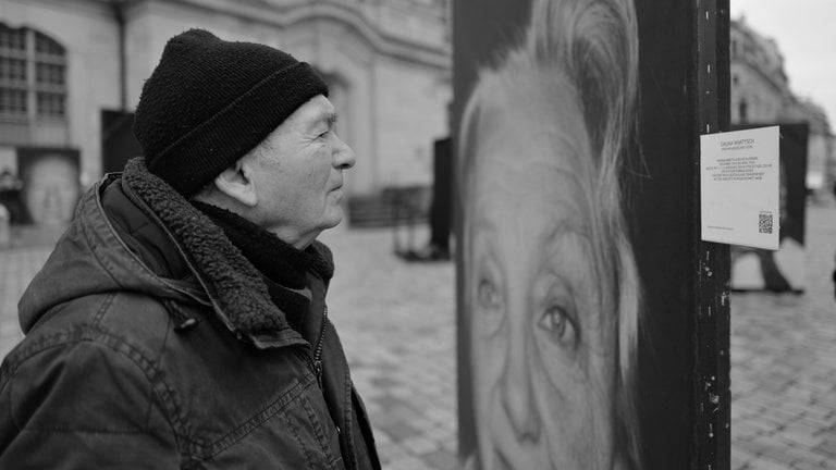 Ein Besucher der Ausstellung "Gegen das Vergessen" sieht sich ein Foto von Luigi Toscano an.