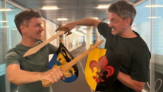 SWR1 Moderatoren Julian Hammerstein und Benedict Walesch in gespielter Duellanten-Pose für das SWR1 HITmach-Duell.