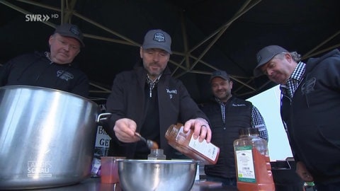 Vier Männer machen Barbecue-Soße