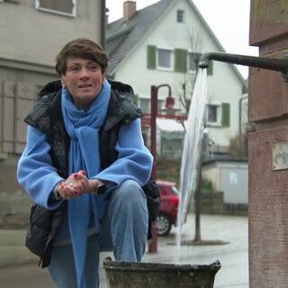 Sonja Faber-Schrecklein steht am Dorfbrunnern von Sulzbach-Laufen