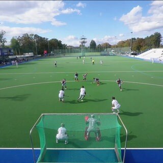 Ein Hockeyspiel hinter einem Tor fotografiert