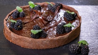 Saftiger Schokokuchen garniert mit Brombeeren, Minze und Schokosplittern: Bei diesem Rezept trifft Sommerfrische auf Schoko-Genuss. 