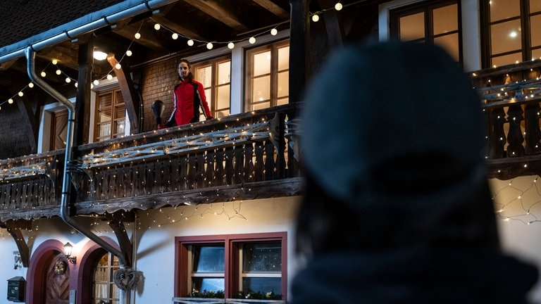 Albert (Alessio Hirschkorn) steht auf dem weihnachtlich beleuchteten Balkon, Sebastian (Dominik Stricker) steht darunter