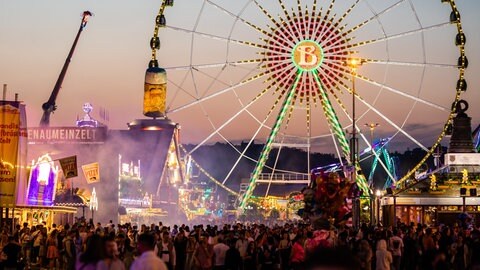 Blaue Stunde auf dem Frühlingsfest in Stuttgart: Am Osterwochenende 2025 startet auf dem Cannstatter Wasen wieder der Rummel.