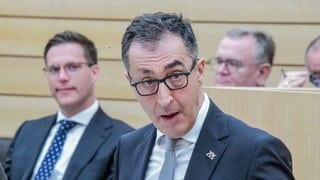 Ministerpräsident Cem Özdemir (Grüne) spricht im Landtag. Dahinter ist Innenminister Manuel Hagel (CDU) zu sehen. Die Diskussion um den Opernneubau in Stuttgart, bei dem sich Özdemir beteiligt hat, zeigt, wie die unterschiedlichen Ansätze der Regierungsparteien liegen.