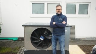Heizungsbauer Michael Hoppe neben einer Wärmepumpe