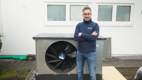 Heizungsbauer Michael Hoppe neben einer Wärmepumpe