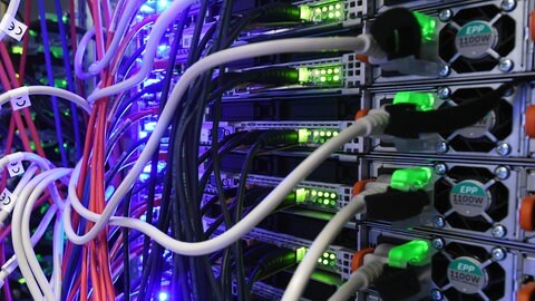 Datenserver mit vielen Kabeln und blinkenden Lichtern 