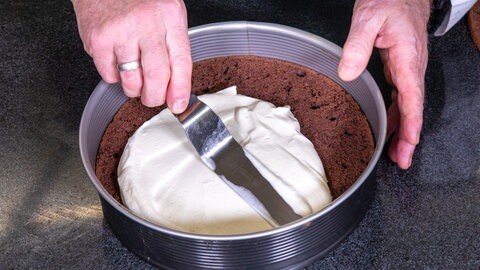 Wie im Rezept beschrieben, wir die Creme der Erdbeer-Schoko-Torte auf dem Schokorührteig verteilt.