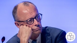 Der Kanzler Friedrich Merz schaut unzufrieden. Viele Deutsche sind mit der Arbeit seiner Bunde·regierung unzufrieden. Rechts das SWR Logo für Leichte Sprache.