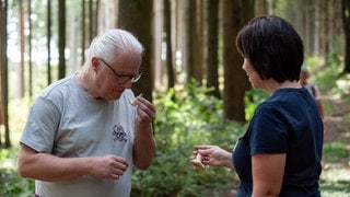 Thomas Regnery riecht an den Pilzen. Grüner Anis-Trichterling riecht stark nach Anis, andere nach muffigem Keller. Das hilft bei der Bestimmung. Man sollte aber zweimal hintereinander riechen, da am Anfang der typische Pilzgeruch oft dominiere.