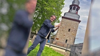 Landesschau-Reporter Marius Zimmermann "stützt" den schiefen Turm von Gau-Algesheim