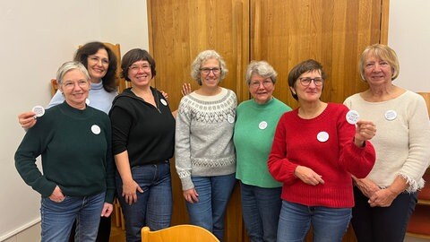 Sieben Frauen der Gruppe "Omas gegen Rechts" aus Neustadt posieren bei einem Orga-Treffen